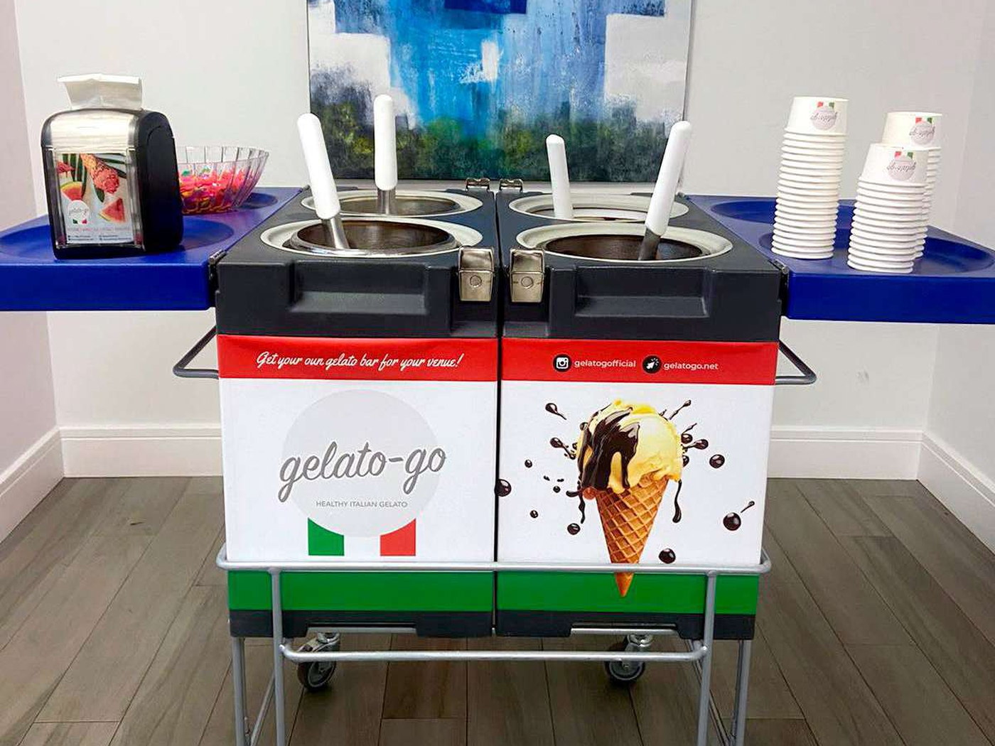 The Gelato Bar — the branded twin-tub Gelato Go cart on wheels, ready to serve beside stacks of branded cups